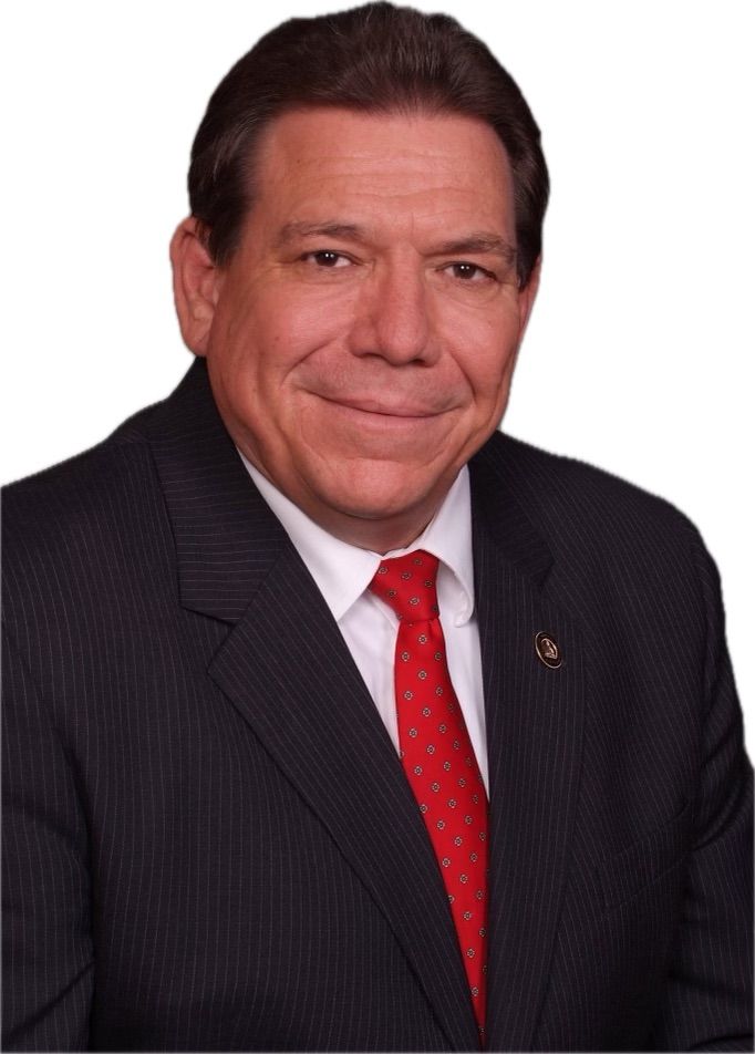 A man in a suit and tie is smiling for the camera
