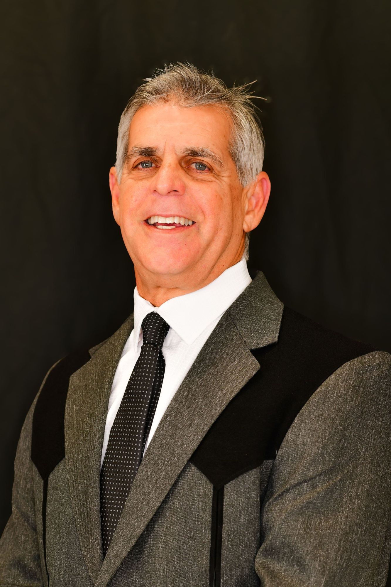 A man in a suit and tie is smiling for the camera.