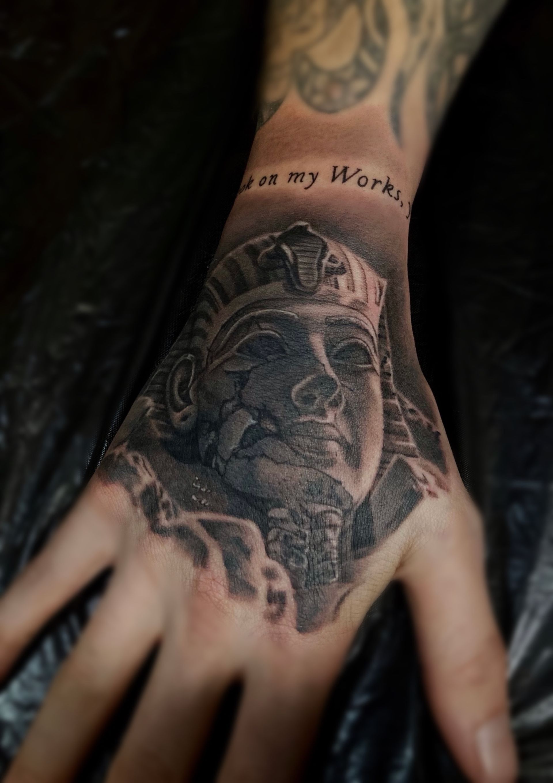 A person has a tattoo of a pharaoh on their hand