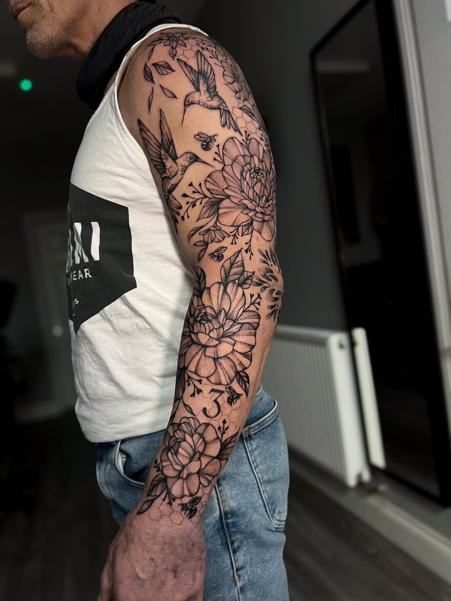 A man with a full sleeve tattoo on his arm.
