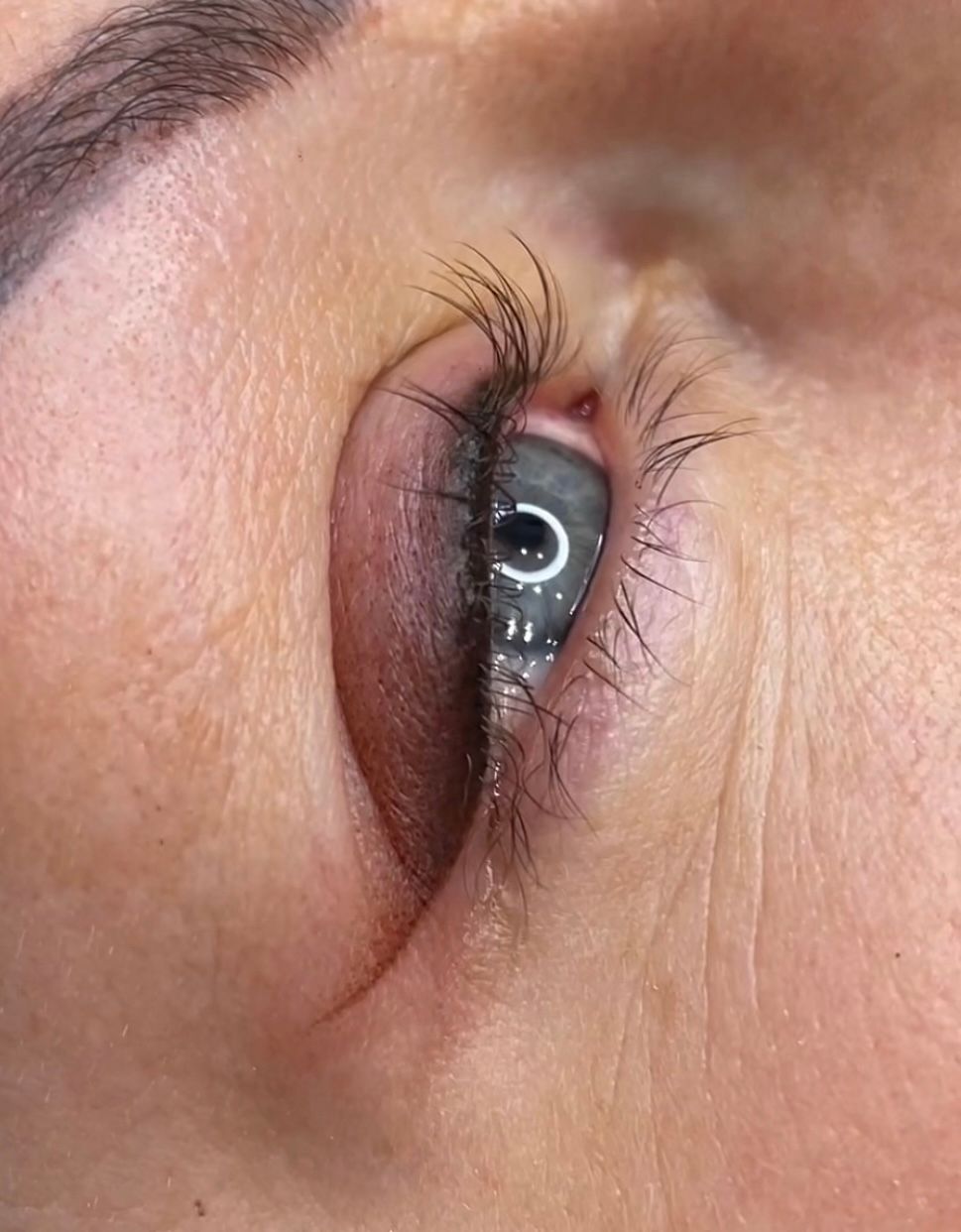A close up of a woman 's eye with long eyelashes.
