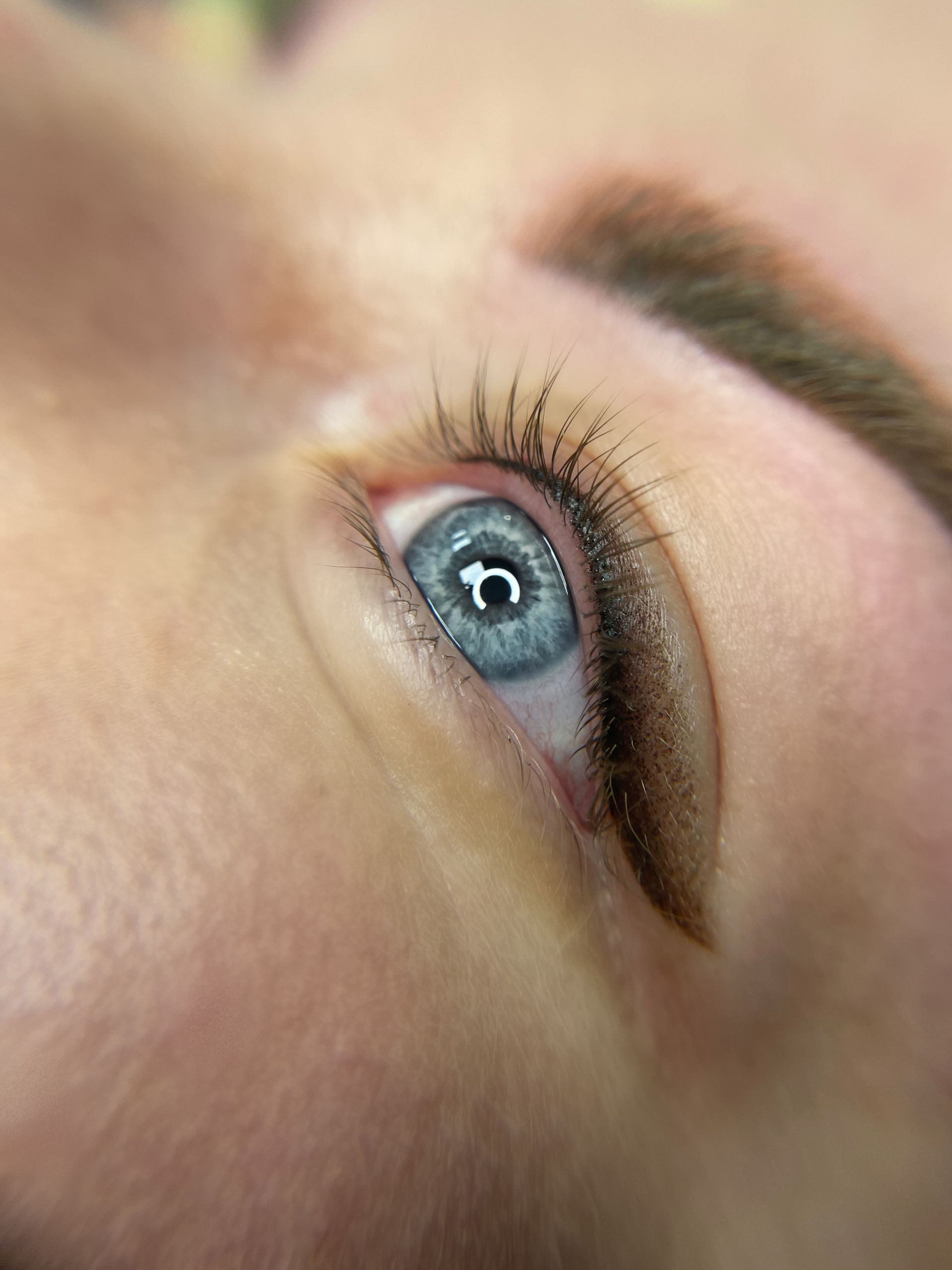 A close up of a woman 's blue eye with long eyelashes.