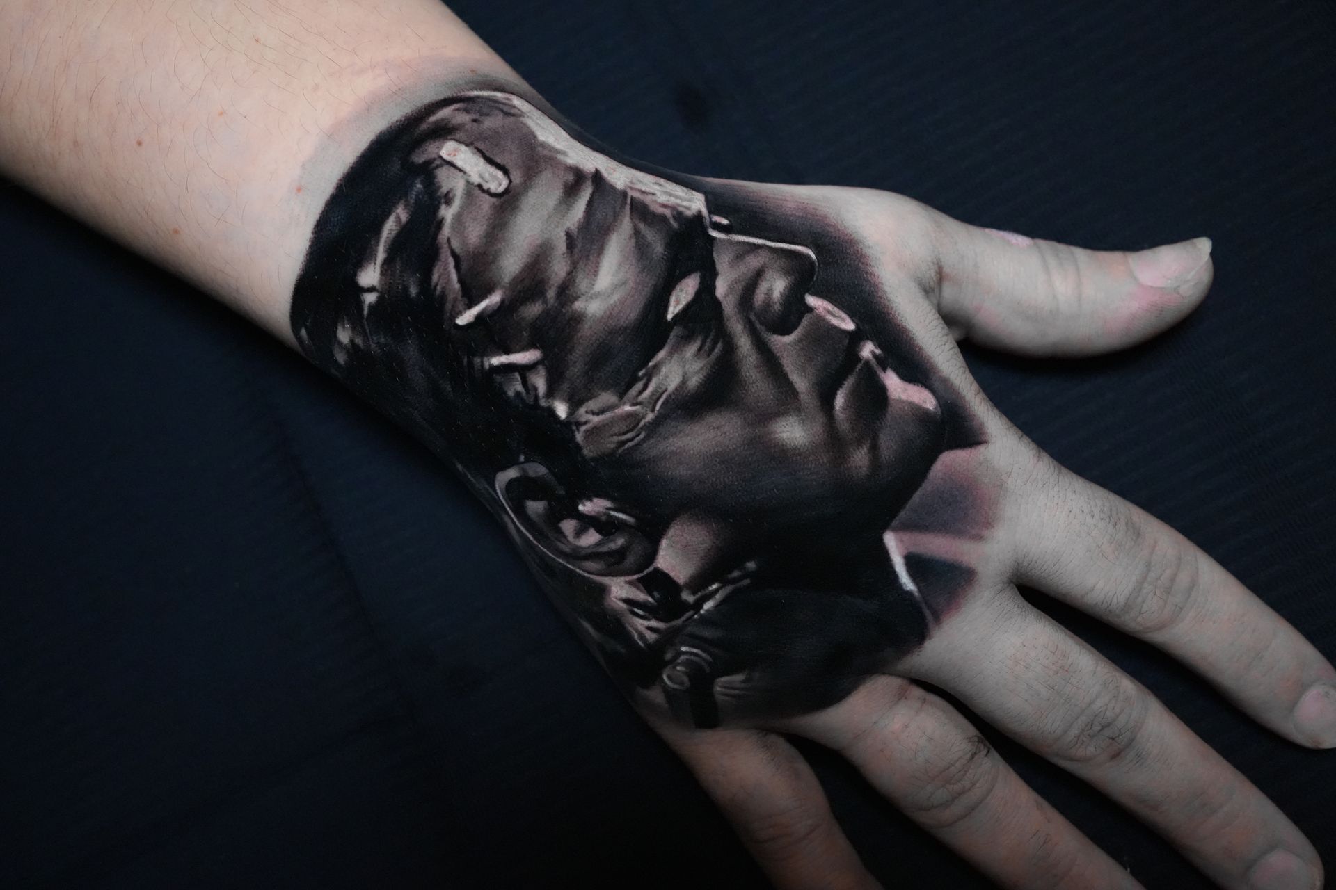 A person has a tattoo of frankenstein on their hand