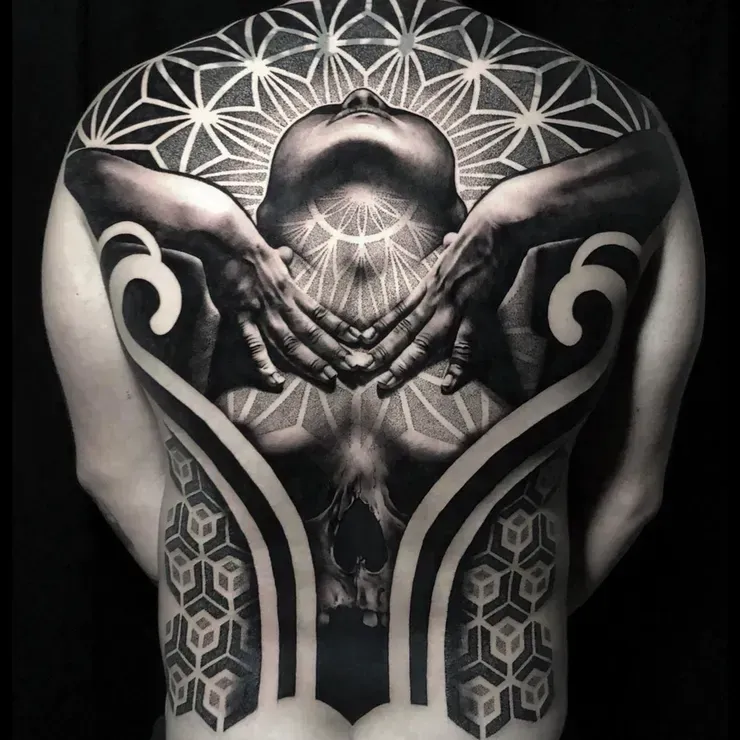 A black and white photo of a man with a tattoo on his back.