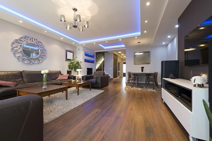 A living room with a couch, chairs, table and television — D’Art Interiors in Eureka, NSW