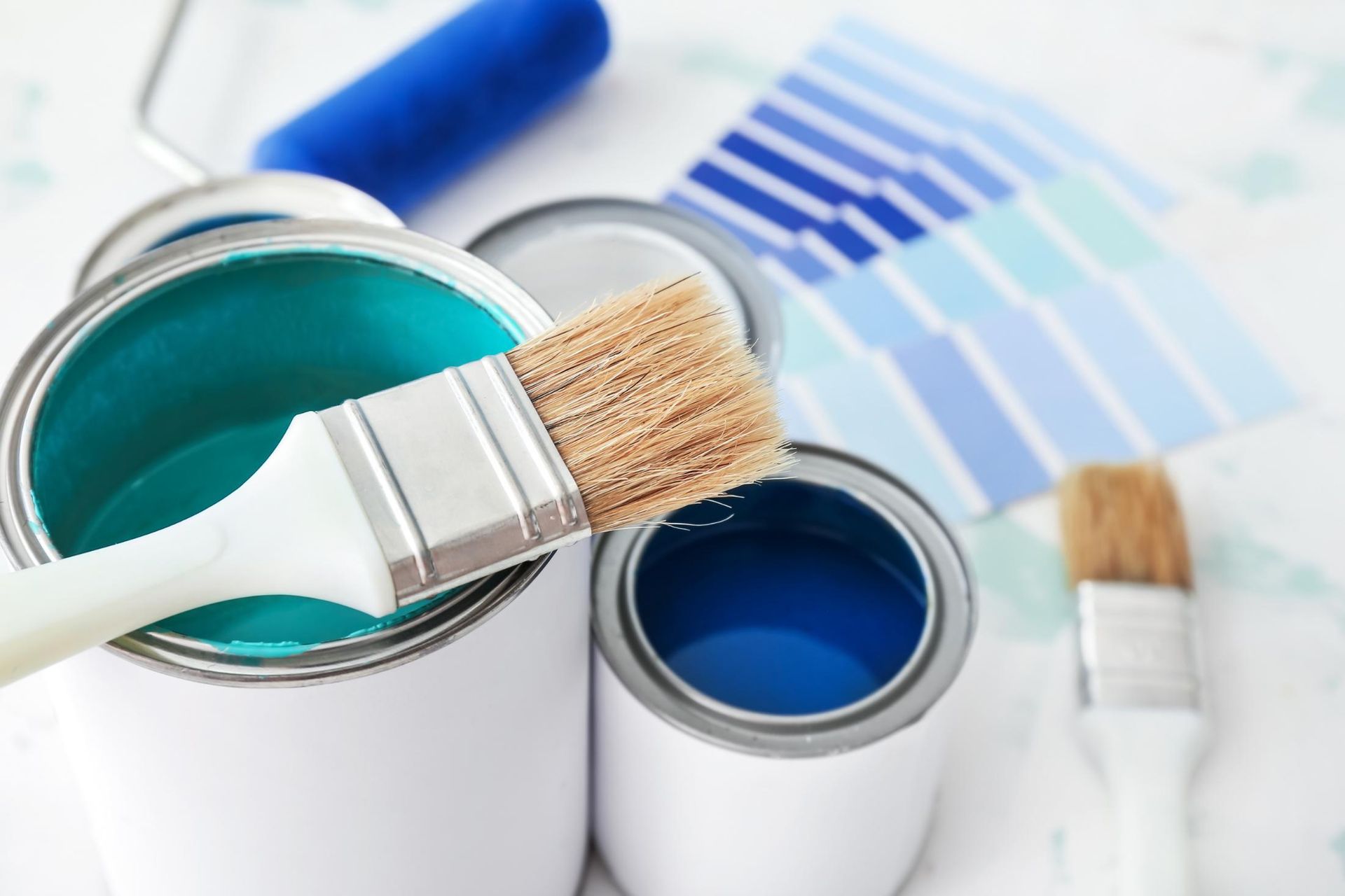 A Can of Blue Paint with a Brush in It — D’Art Interiors in Kingscliff, NSW
