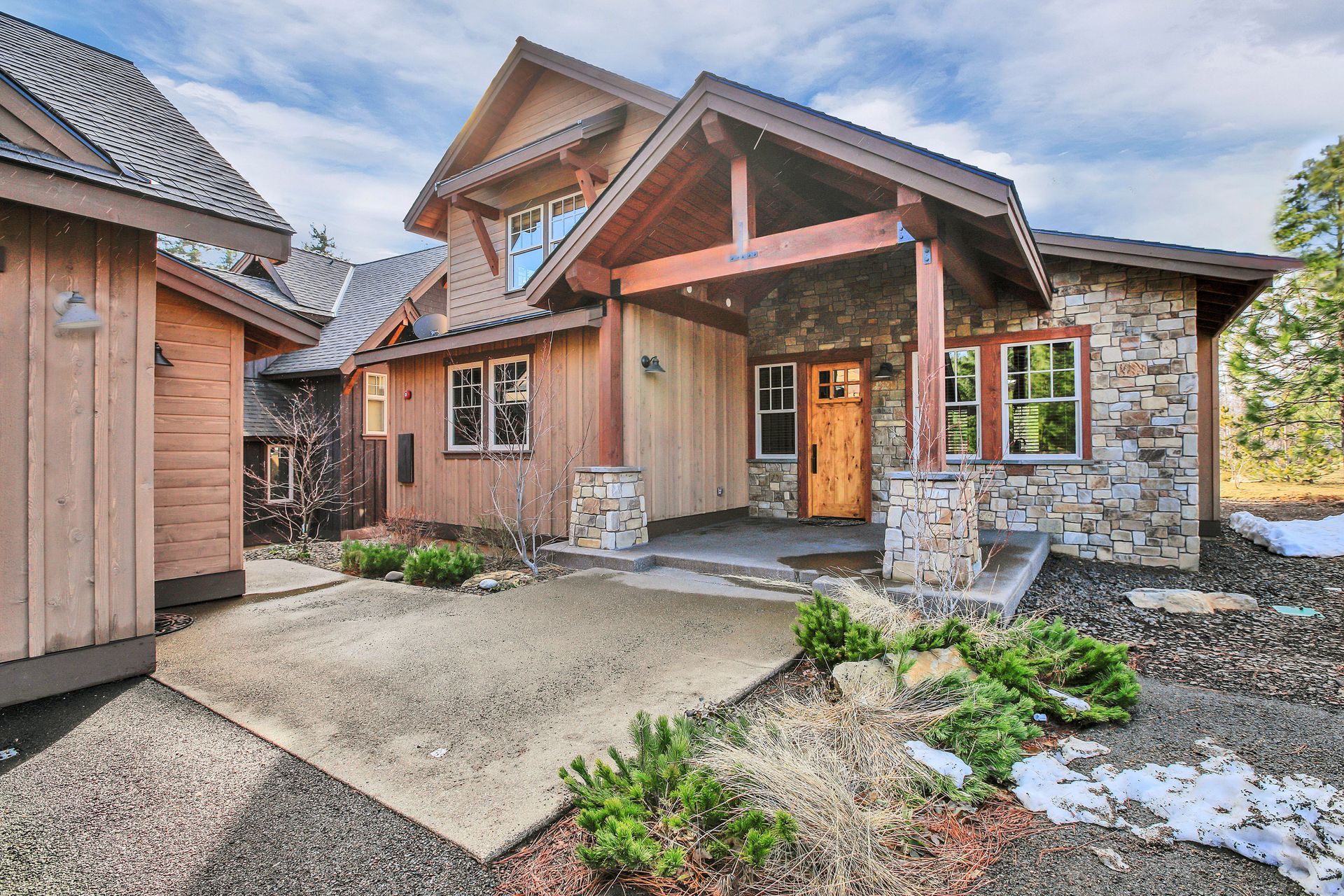 Beautiful craftsman home with wood and stone exterior, covered porch and entry columns.