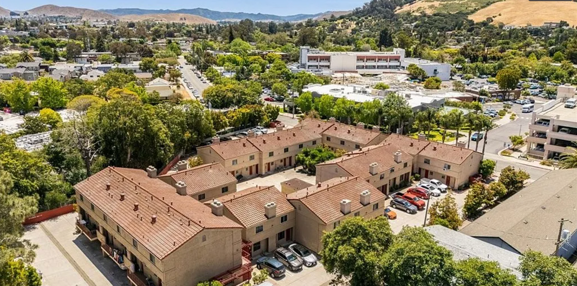 Panoramic view of mountain range and valley under a blue sky.
