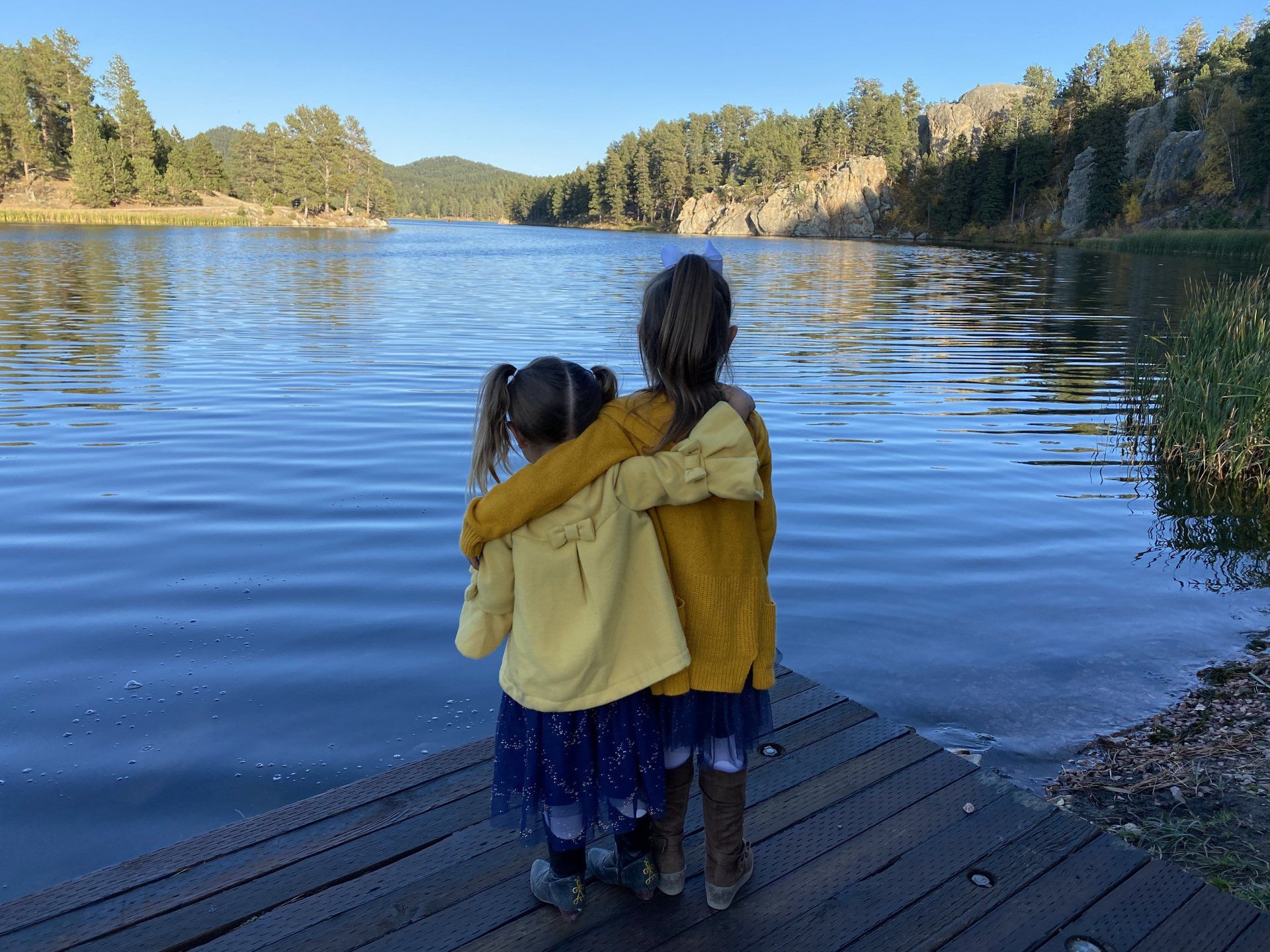 Photo of girls looking at the view on the lake and mountains