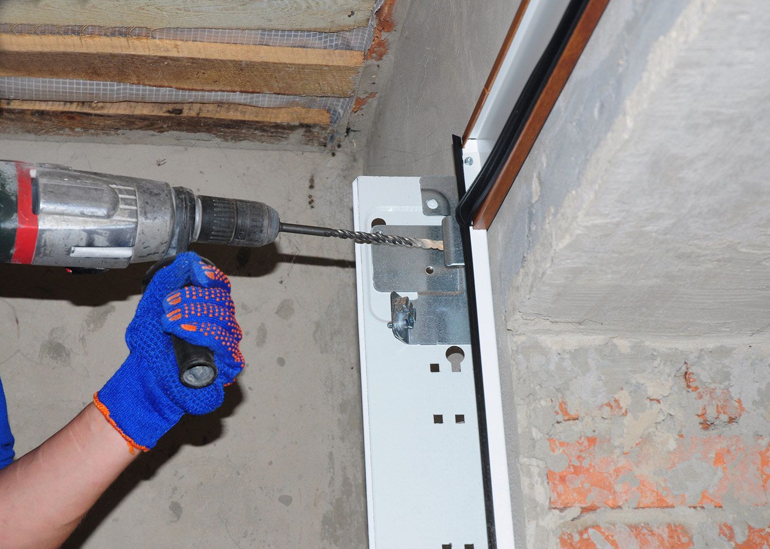 Worker Using a Drill to Install Garage Door