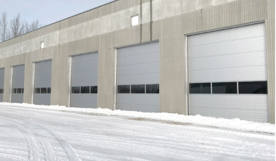 Exterior of a Lexus dealership building with large windows, a service entrance, and a Lexus logo.
