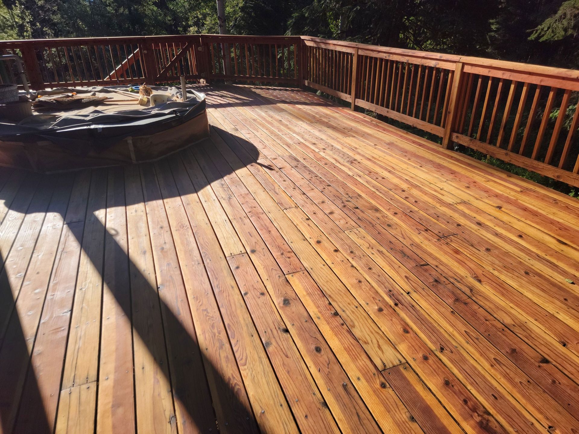 A large wooden deck with a hot tub on it