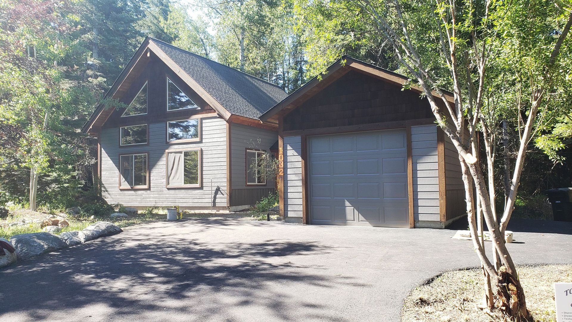 A house with a garage and trees in front of it