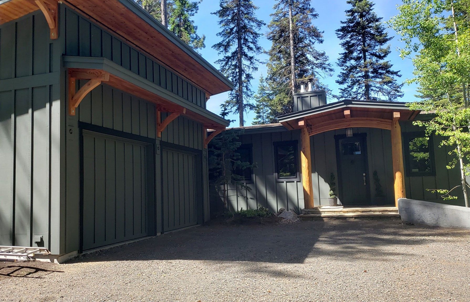 A house with a garage and trees in the background