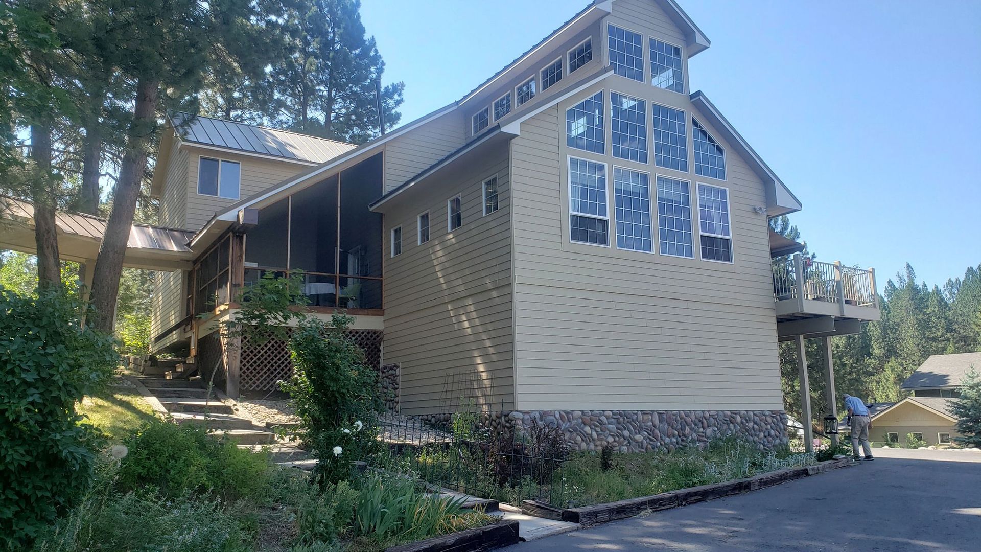 A large house with a lot of windows is surrounded by trees.