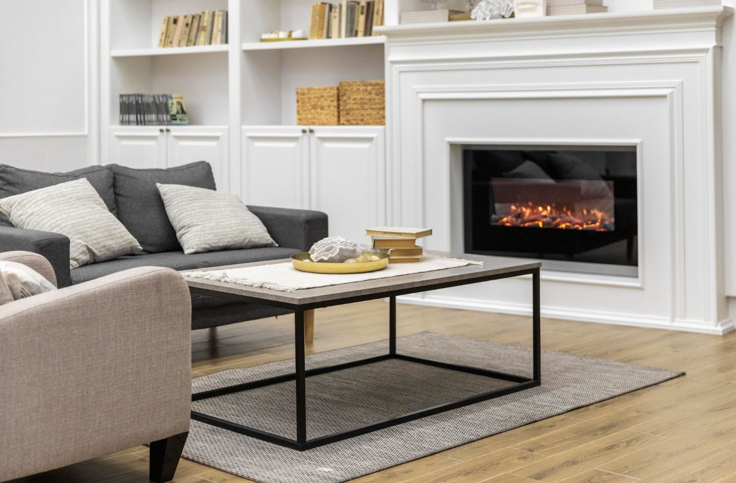 A living room with a couch , chair , coffee table and fireplace.