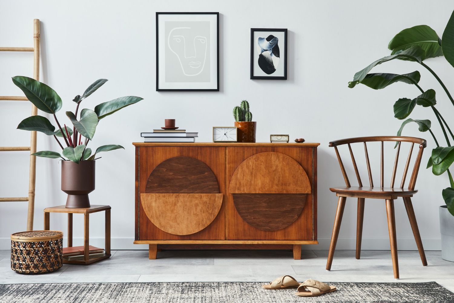 A living room with a wooden cabinet , chair , plants and a ladder.