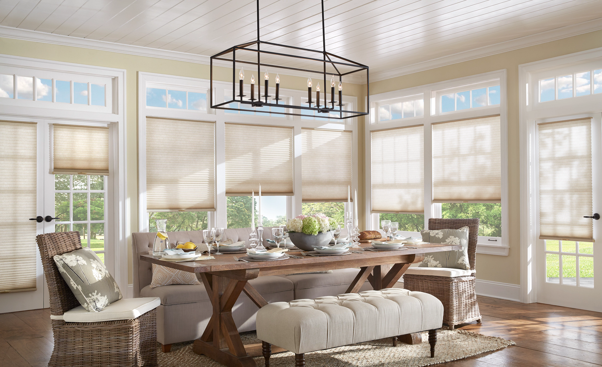 A dining room with a table and benches and a chandelier hanging from the ceiling.