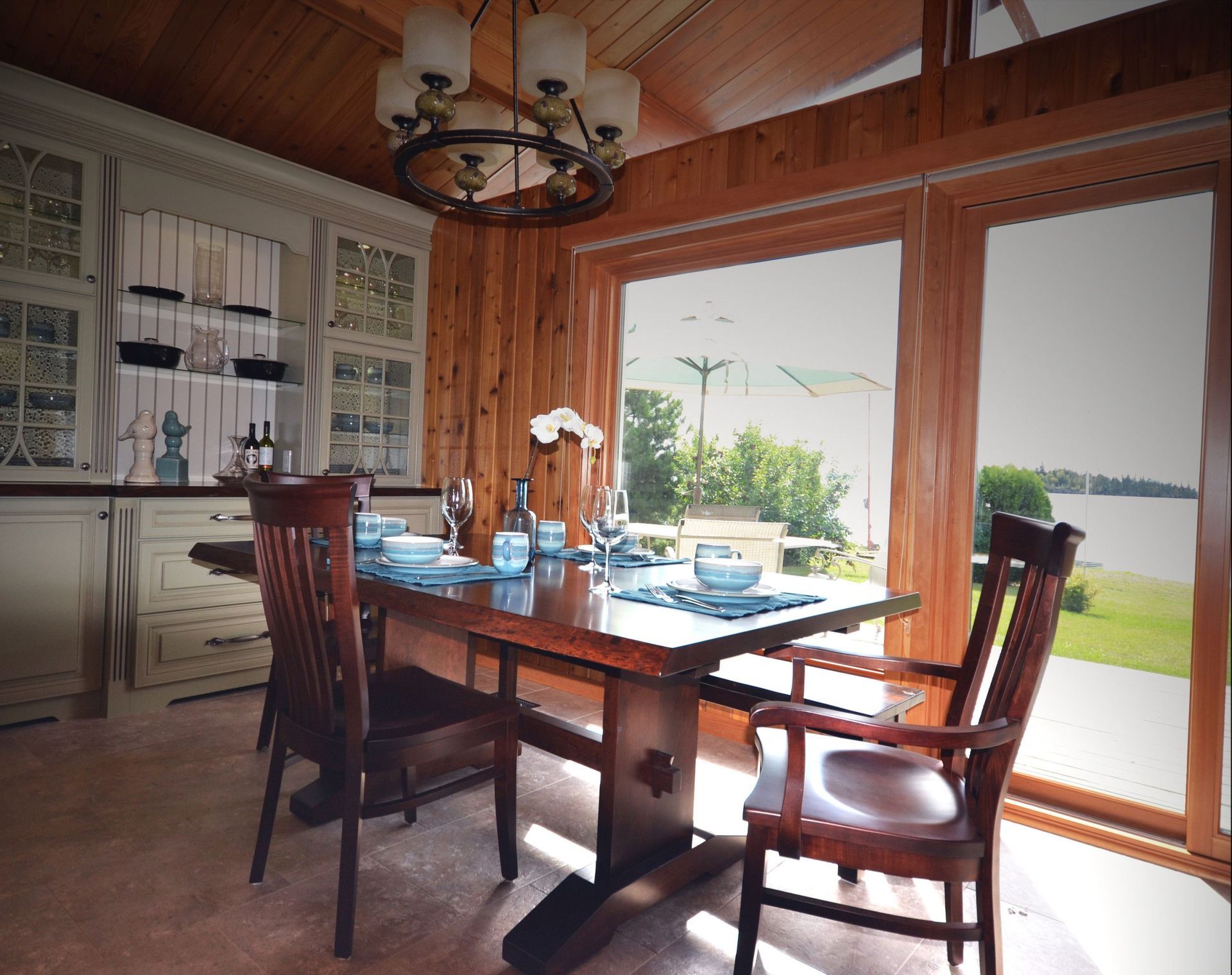 A dining room with a table and chairs and a large window