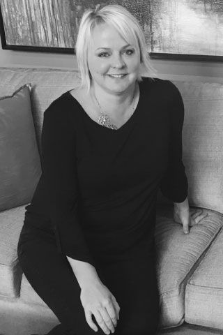 A woman is sitting on a couch in a black and white photo.