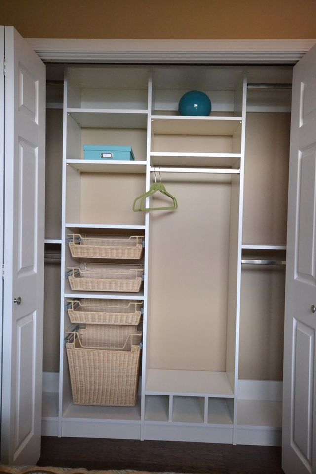 A closet with wicker baskets and a blue ball on top