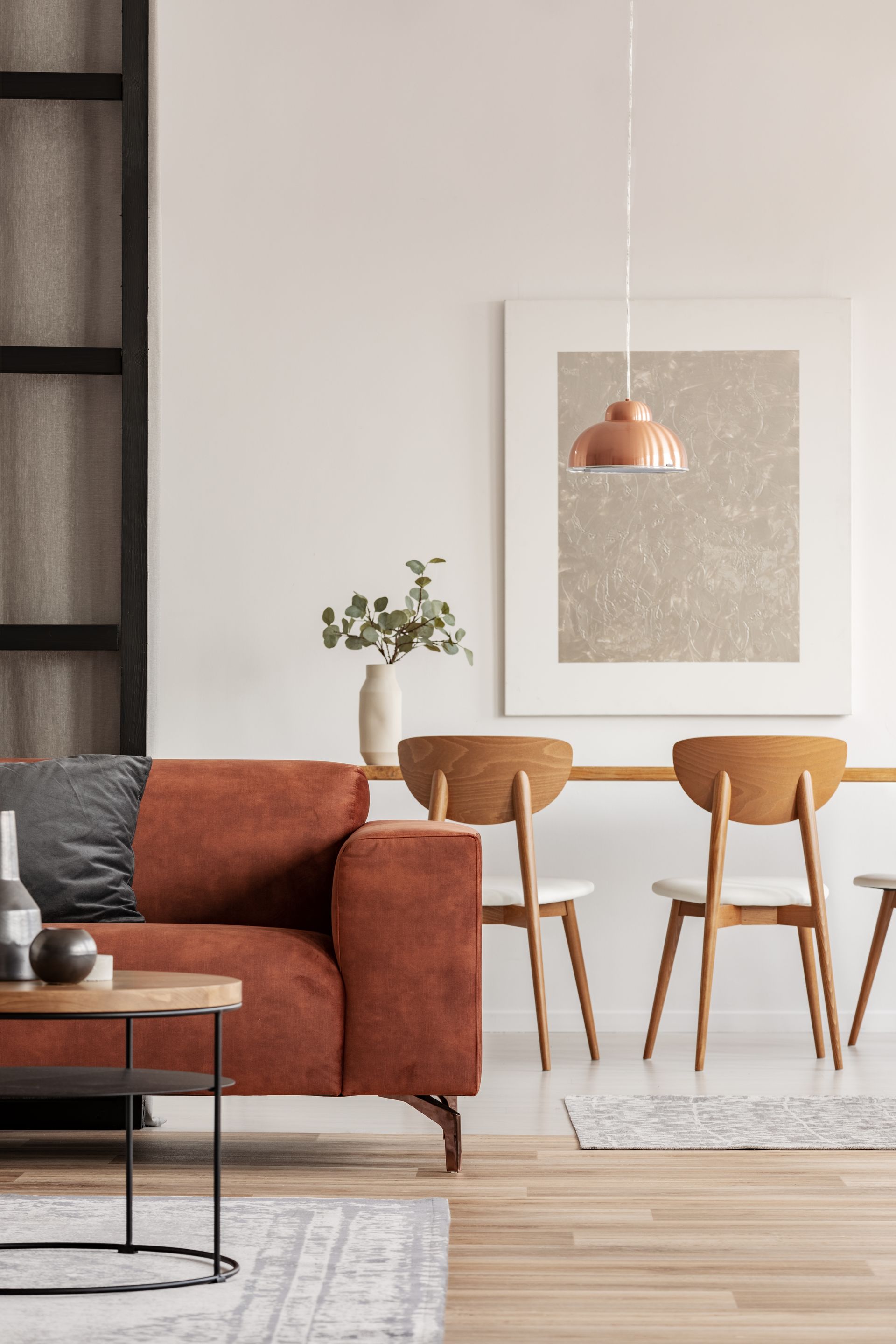 A living room with a red couch , table and chairs.