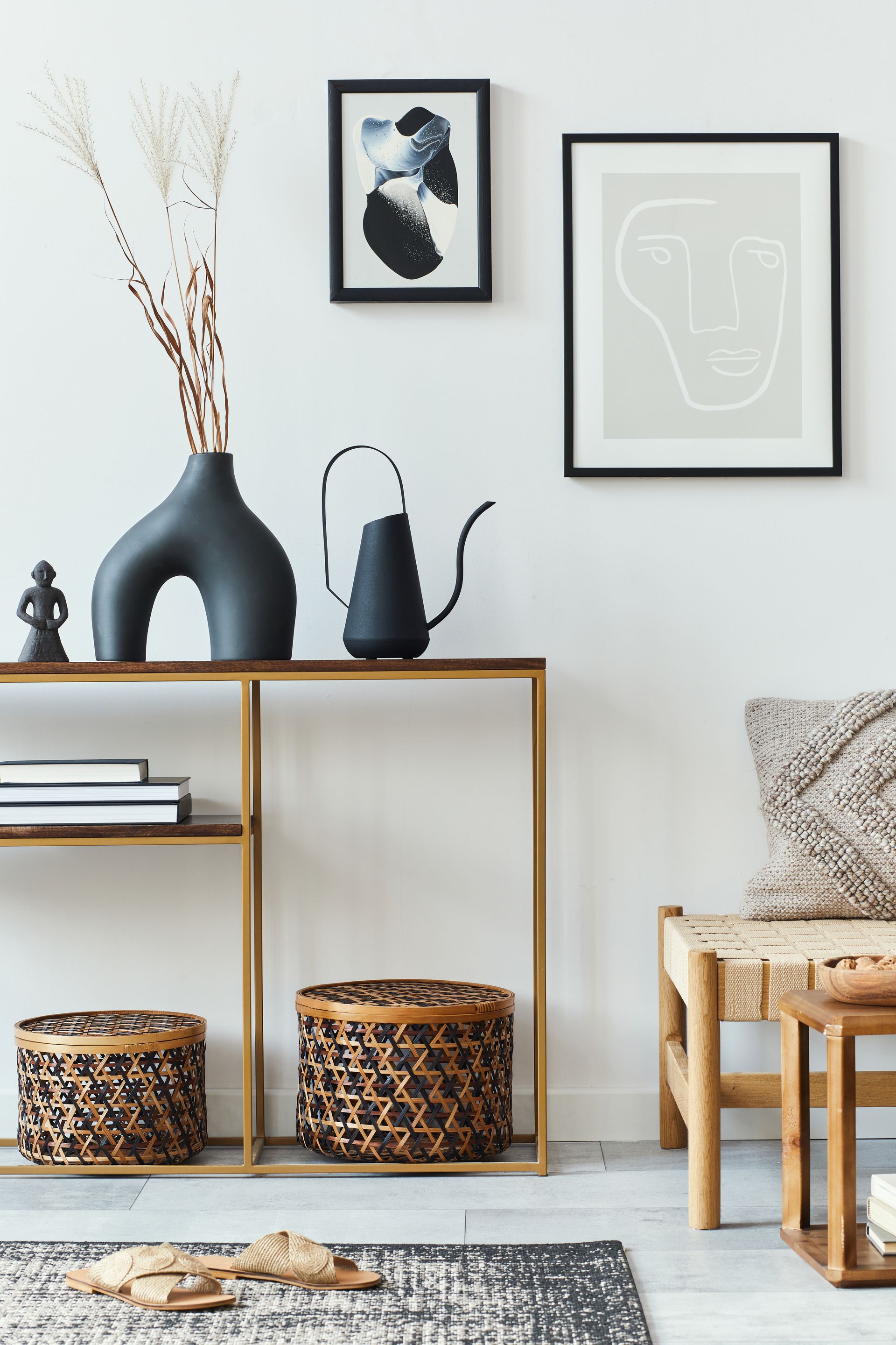 A living room with a table , vases , baskets and a chair.