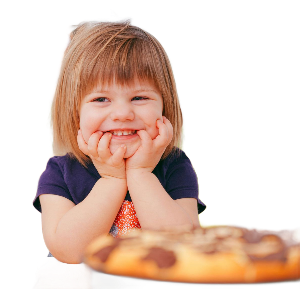 Smiling child with hands on chin, looking at a blurred pastry.