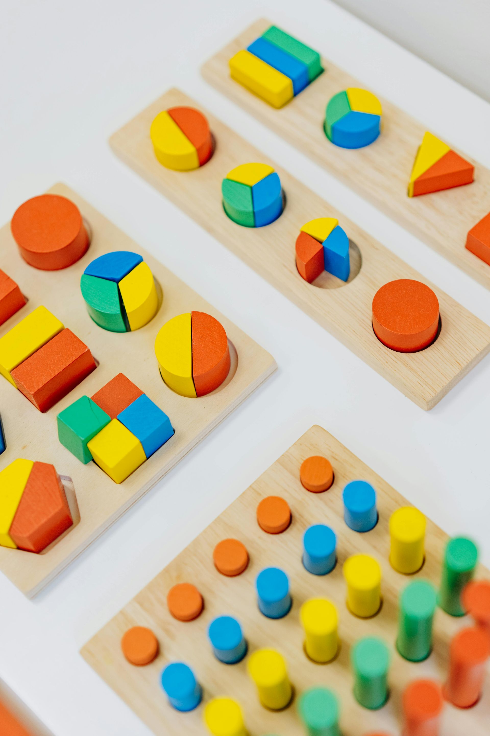Wooden shape sorter toys with colorful geometric blocks on a white surface.