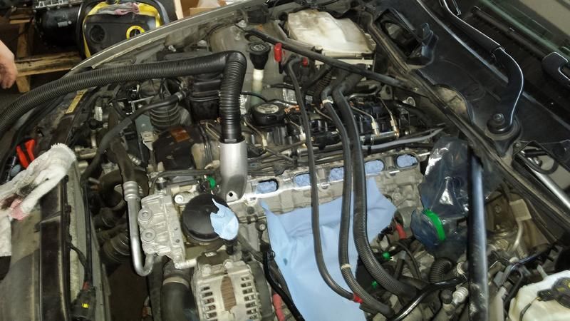 Ein Automotor, dessen Teile zur Reparatur ausgebaut wurden. Schwarze Schläuche, Werkzeuge