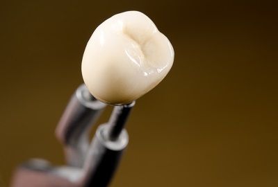 A close up of a dental crown on a dental drill.