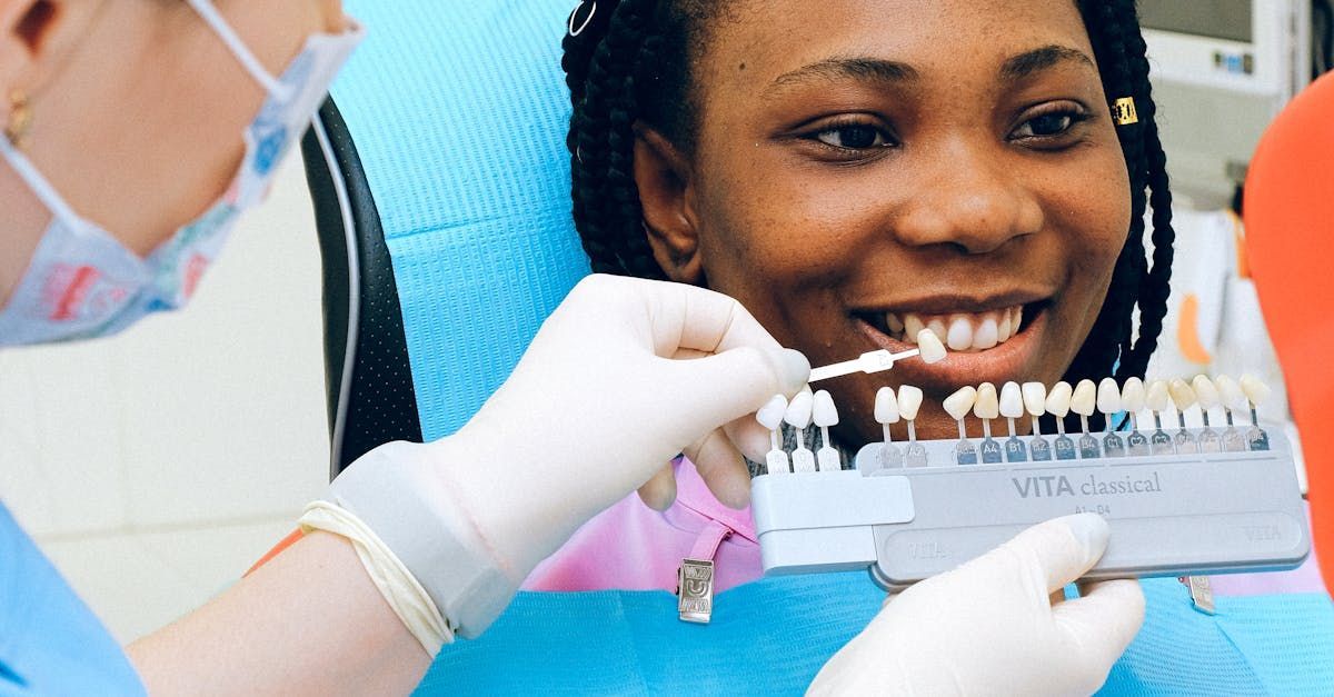 A woman is sitting in a dental chair while a dentist examines her teeth.