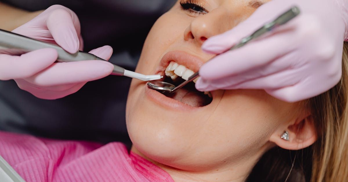 A woman is getting her teeth examined by a dentist.
