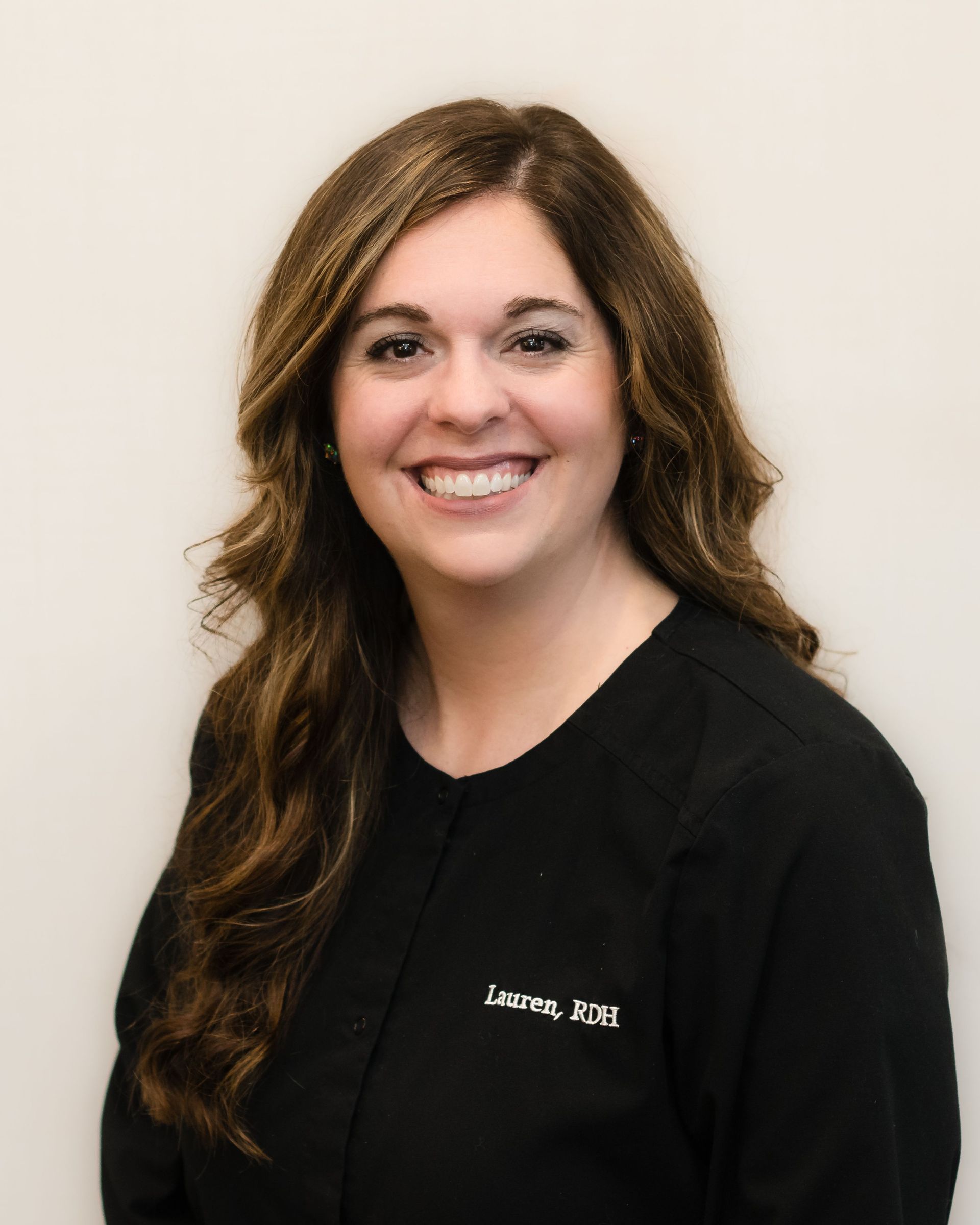 A woman in a black shirt is smiling for the camera.