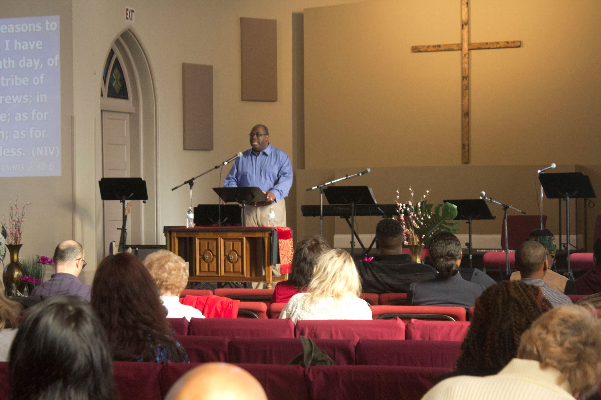 A man stands at a podium in front of a crowd of people in a church