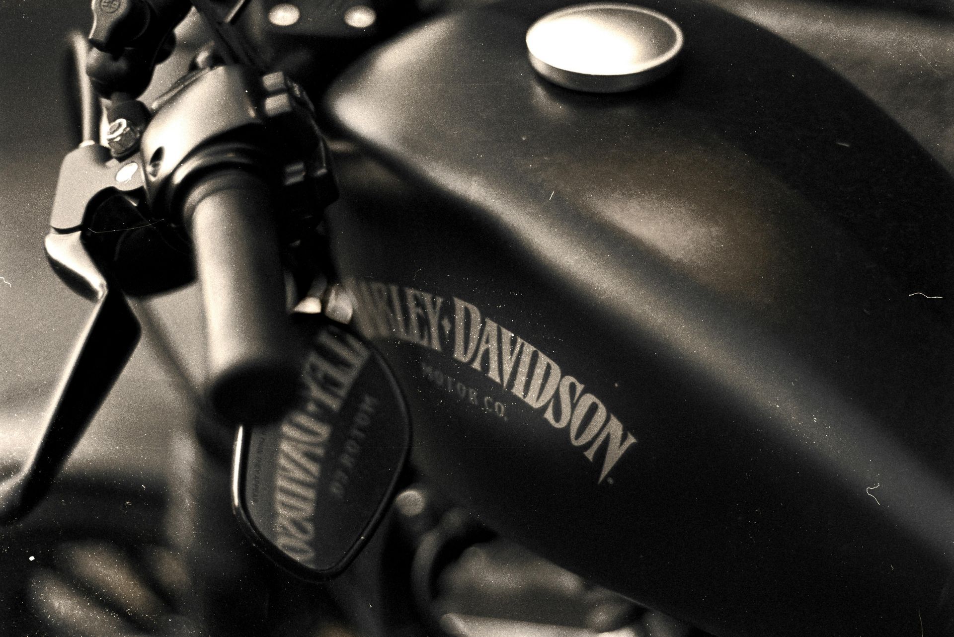 Close-up of a black Harley-Davidson motorcycle fuel tank and handlebars