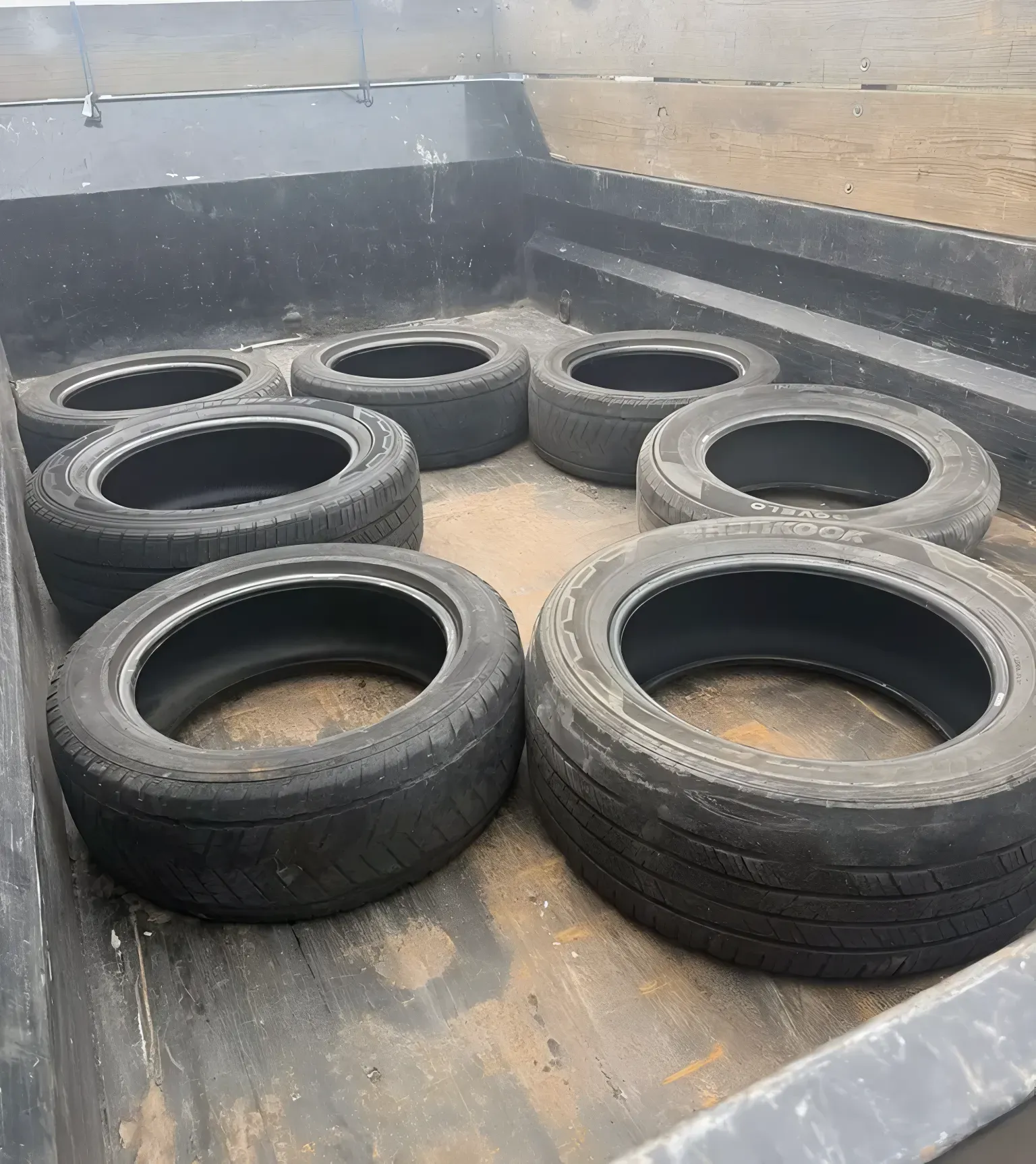 Eight black tires inside a truck bed.