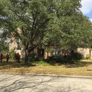 A group of people are standing in front of a house.