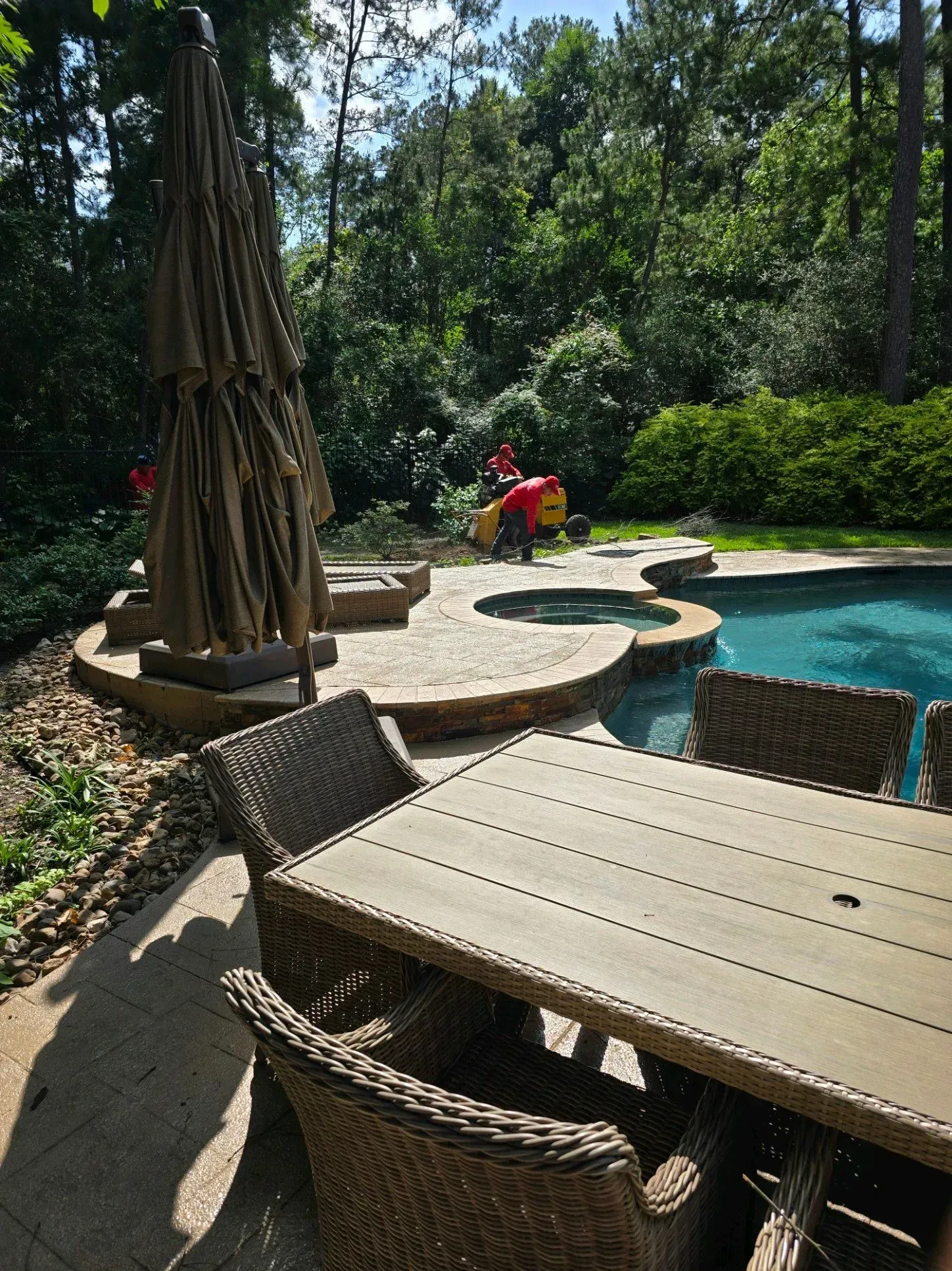 A table and chairs are sitting next to a pool.