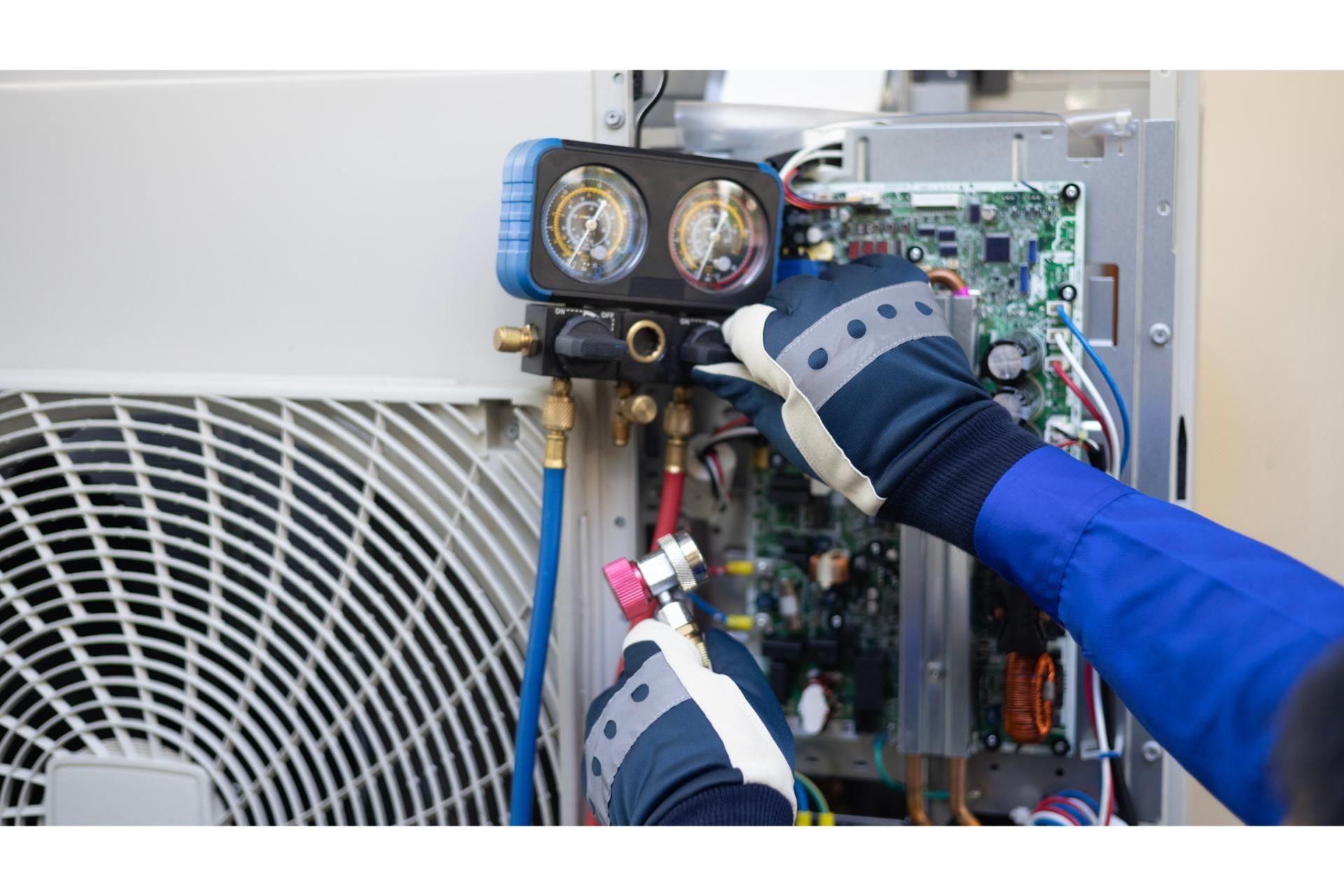 A technician in blue sleeves and gloves uses a manifold gauge set to service an air conditioning unit.