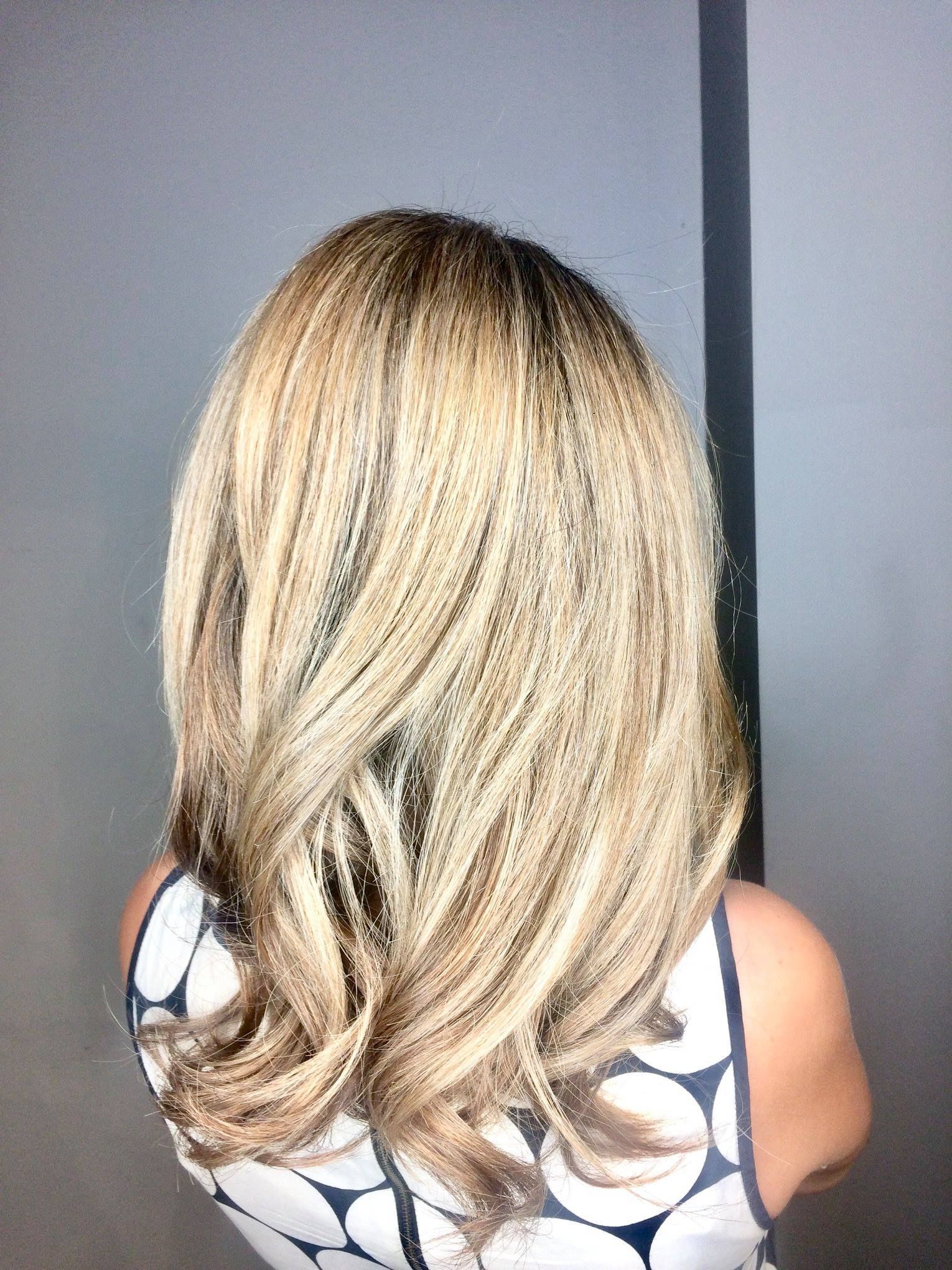 Woman with light brown and blonde layered hair, in patterned tank top.