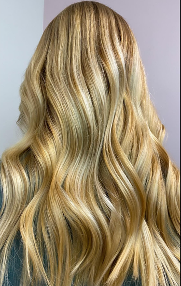 Blonde wavy hair; highlights and lowlights create depth.