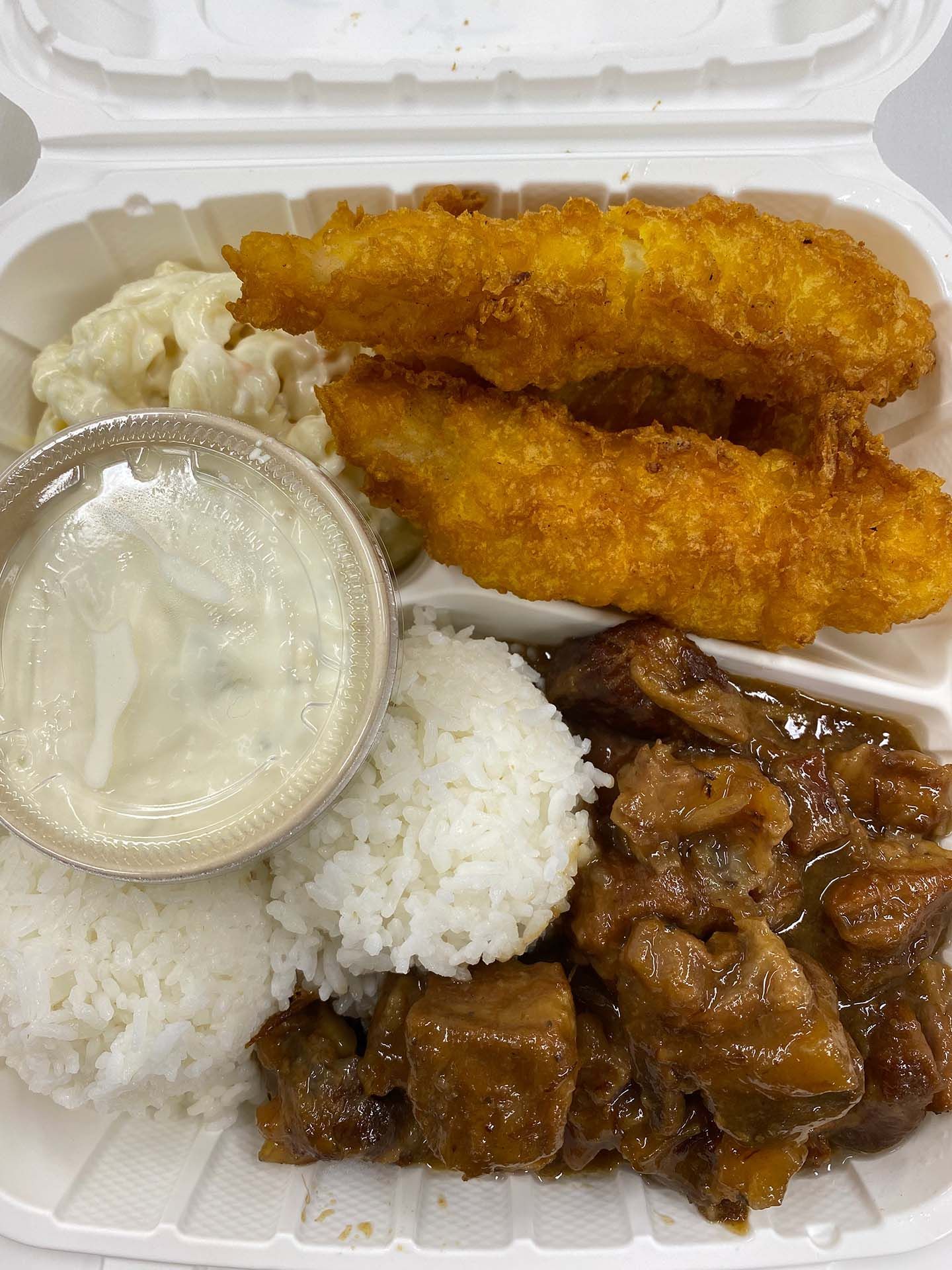 Plate of fried fish, beef stew, rice, macaroni salad, and dipping sauce