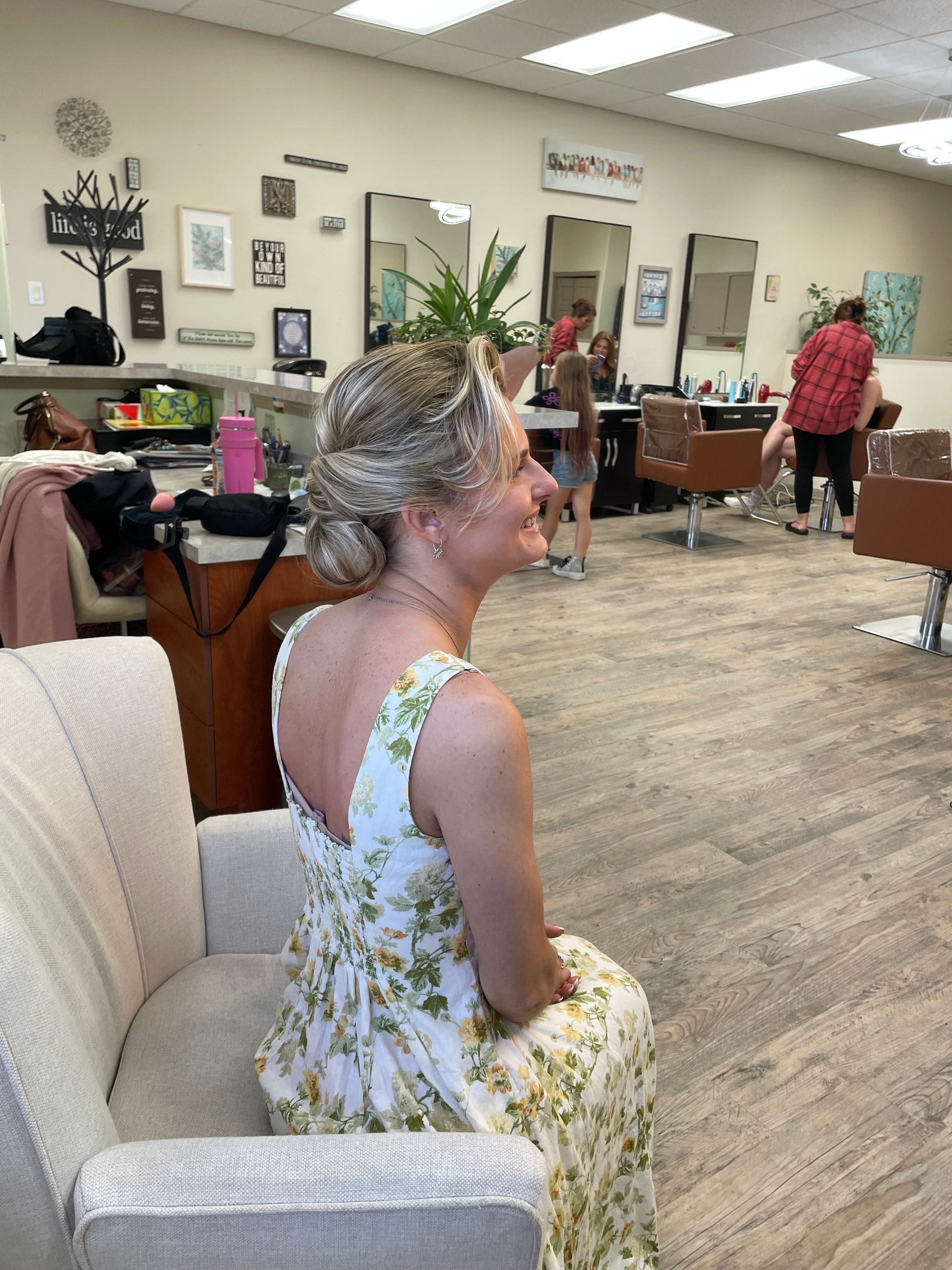 A woman is sitting in a chair in a salon.