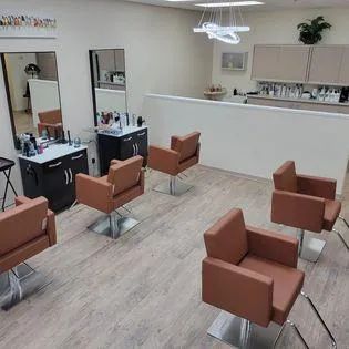 A salon with a lot of chairs and mirrors.