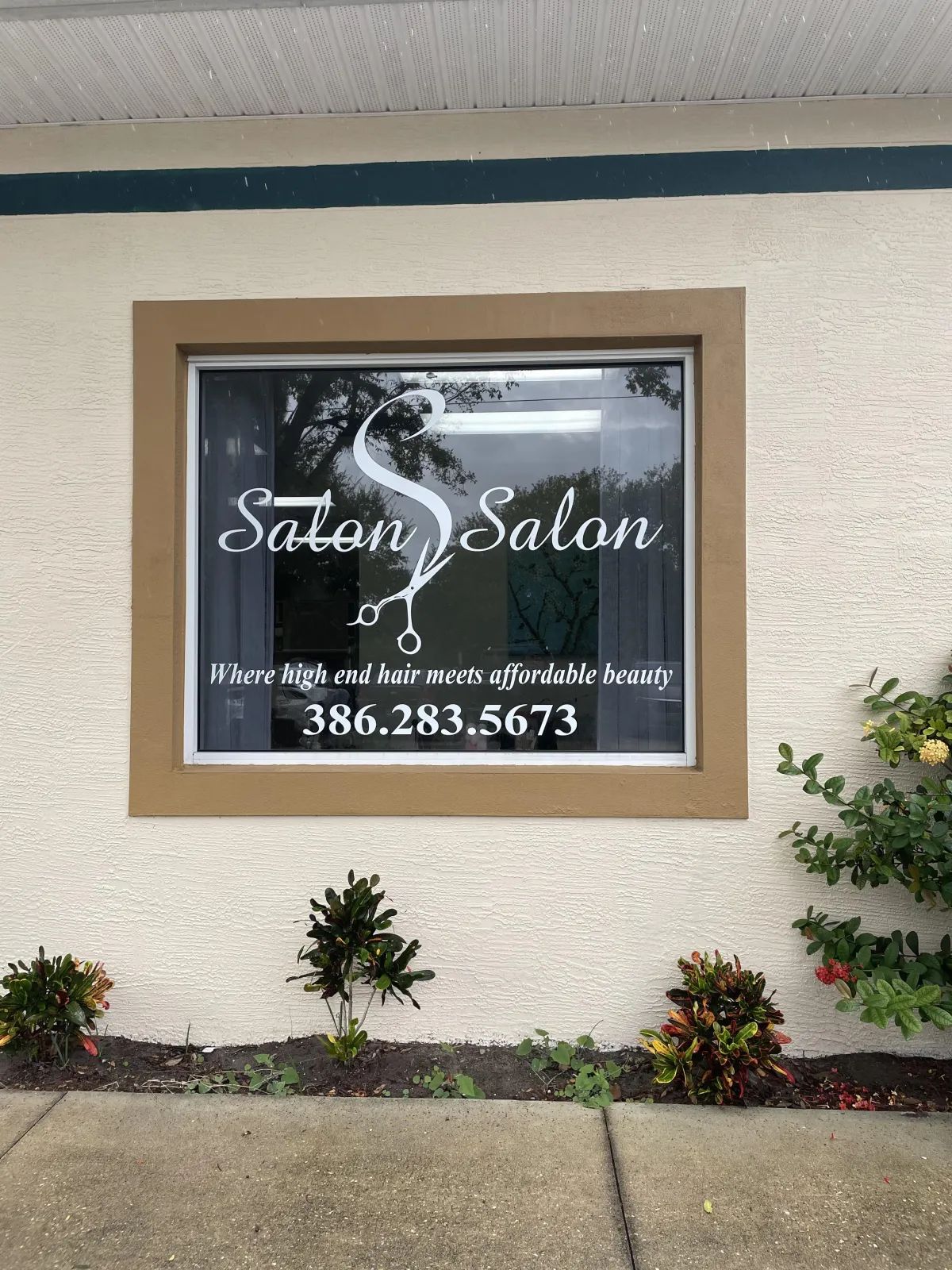 A white building with a window that says salon salon