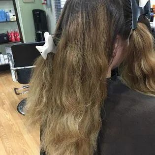 A woman is getting her hair dyed in a salon