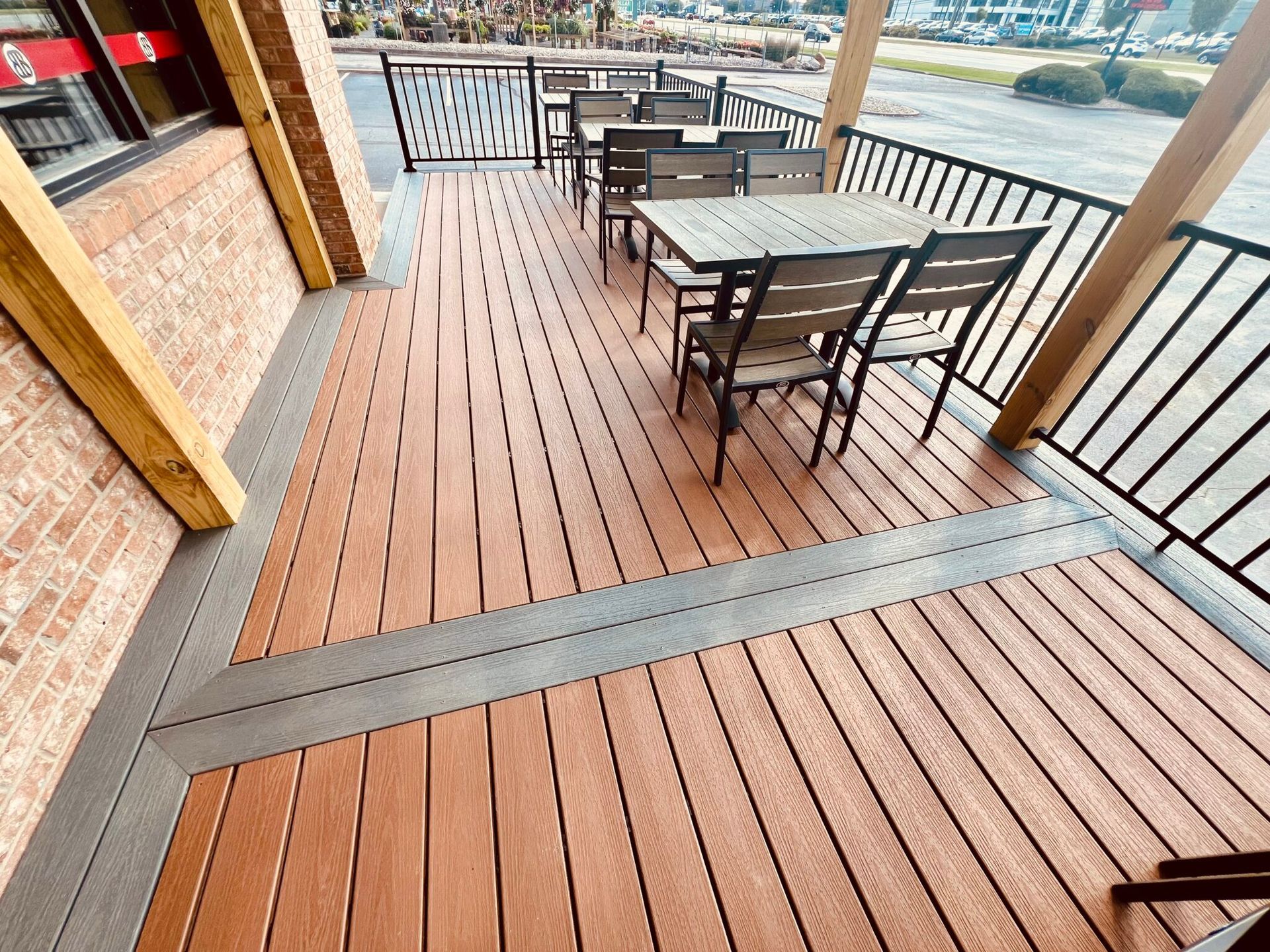 A large wooden deck with tables and chairs on it.