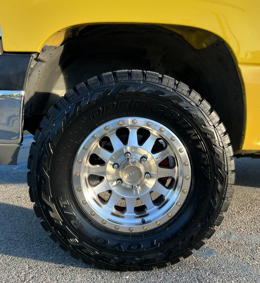 A close up of a tire on a yellow truck