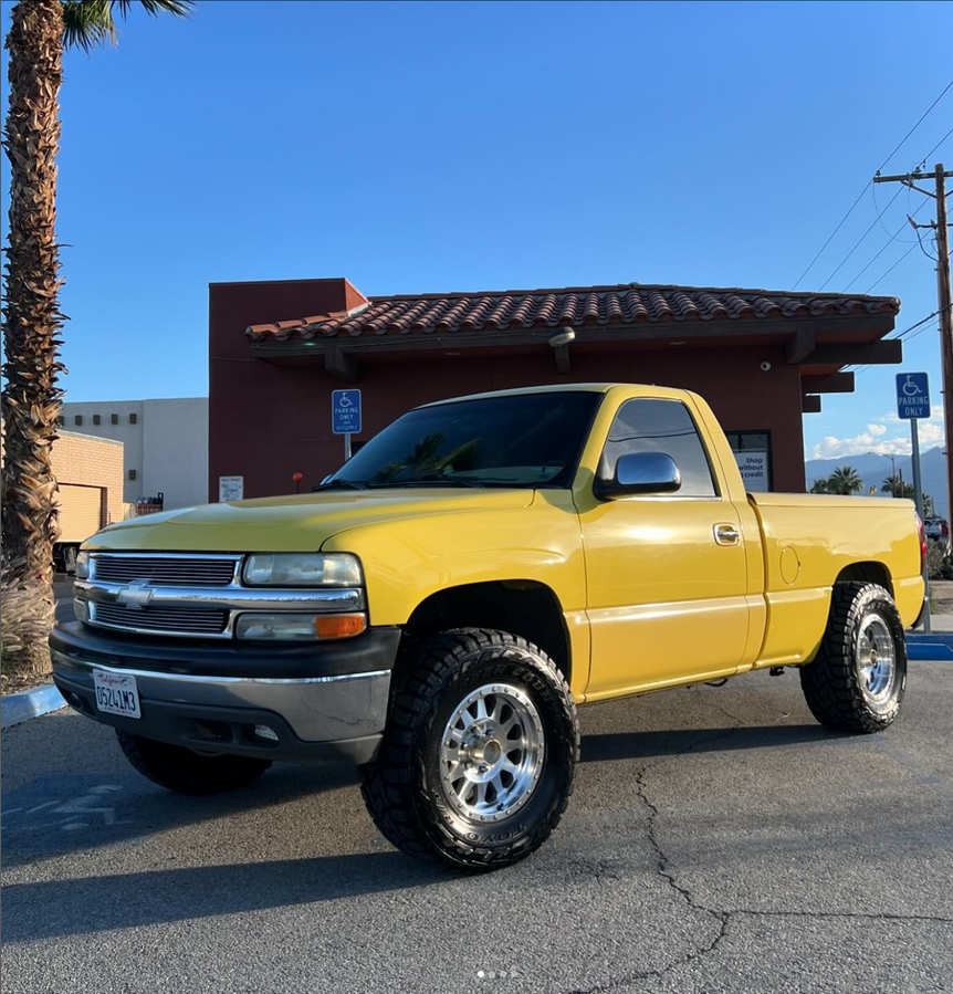 A yellow truck is parked in a handicapped parking spot